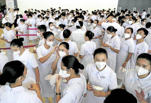 PHOTO: Nursing students wait for the capping and pinning ceremony.  STORY: PNA hits ‘band-aid’ solution to nursing shortage problem