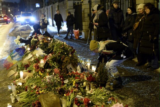 People lay flowers and candles at a makeshift memorial for the late Russian opposition leader Alexei Navalny outside the former Russian Embassy in Helsinki, Finland 